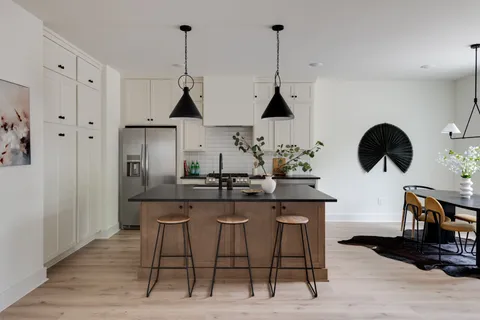 a kitchen with a table chairs and white cabinets