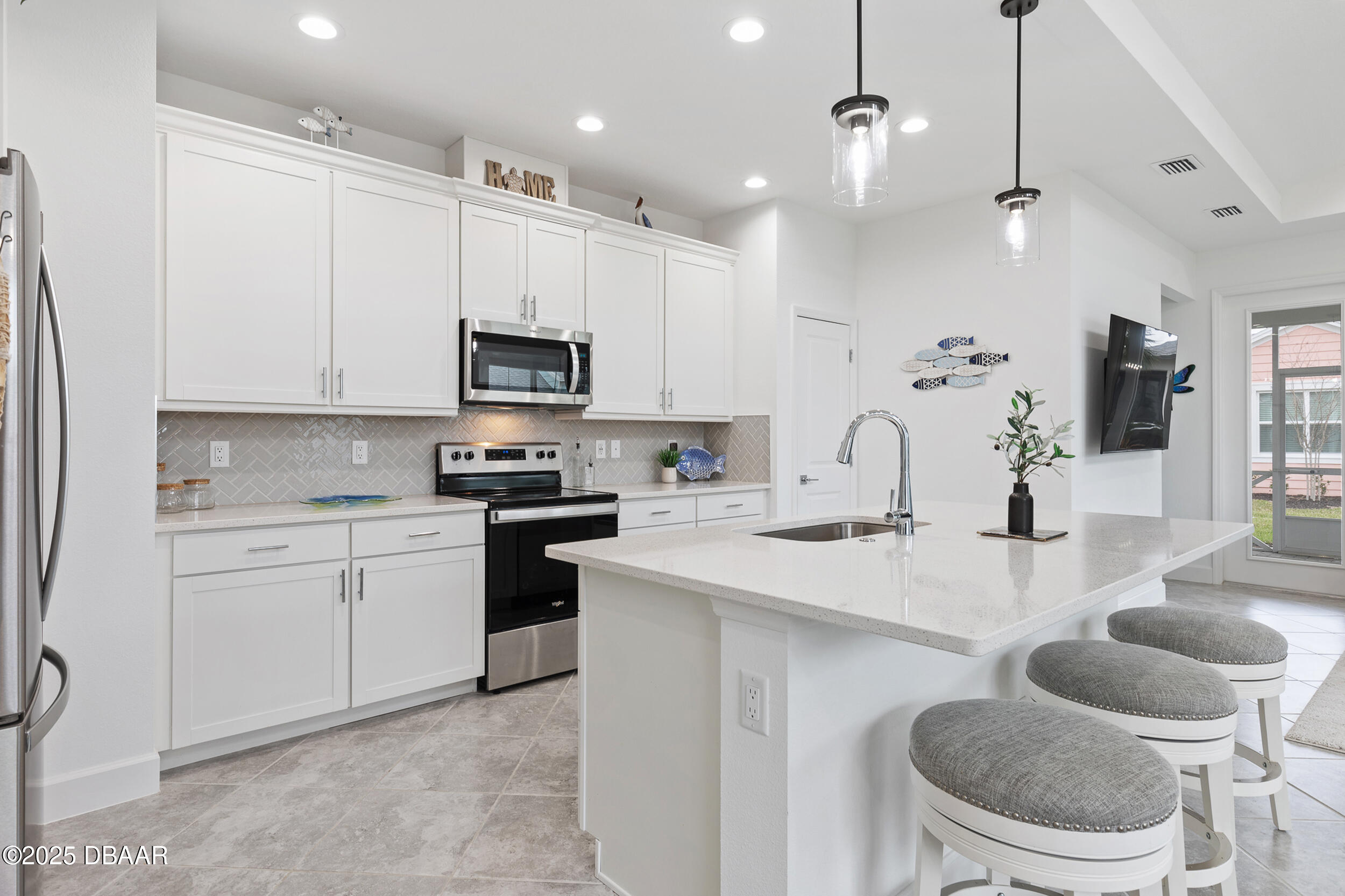 208 Ocean Hammock Loop Daytona Beach, FL 32124 - Photo 8 of 91 a kitchen with granite countertop a sink and a stove top oven with white cabinets
