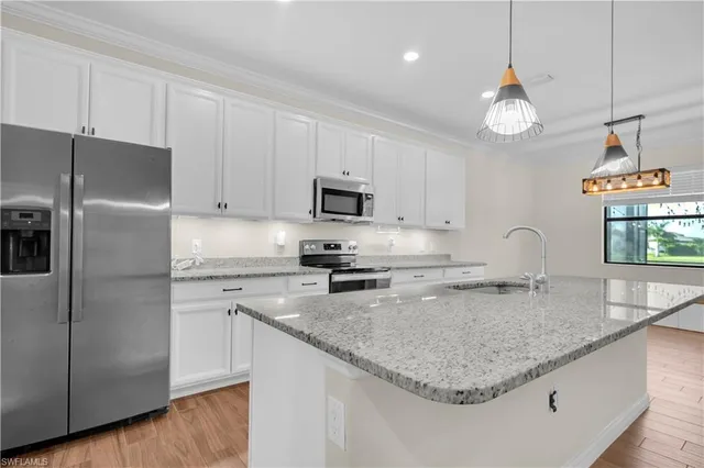 a kitchen with stainless steel appliances granite countertop a sink a refrigerator a stove a microwave and cabinets