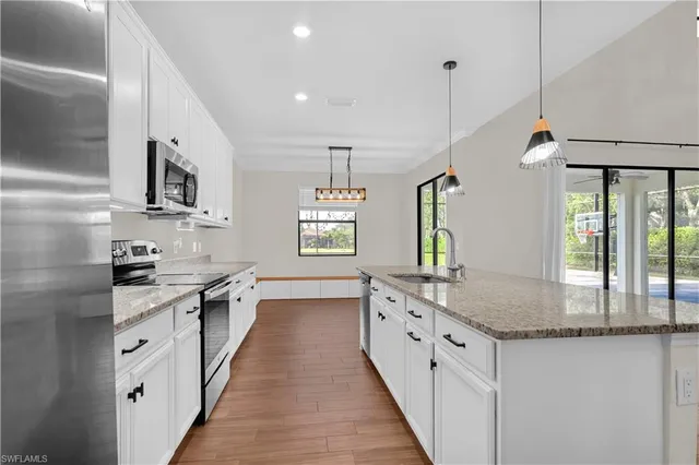 a large kitchen with granite countertop a stove and a sink