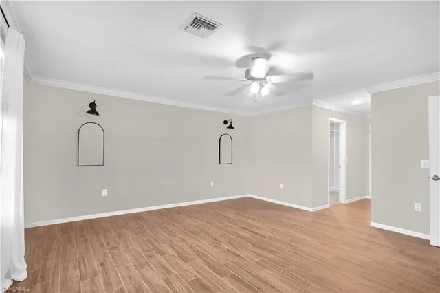 a view of a room with wooden floor and ceiling fan