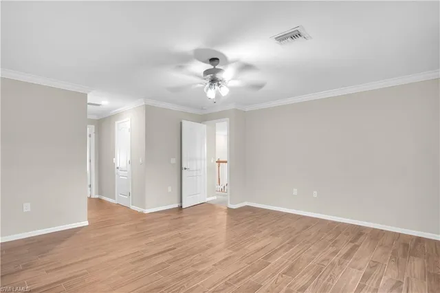 a view of a room with wooden floor and a ceiling fan