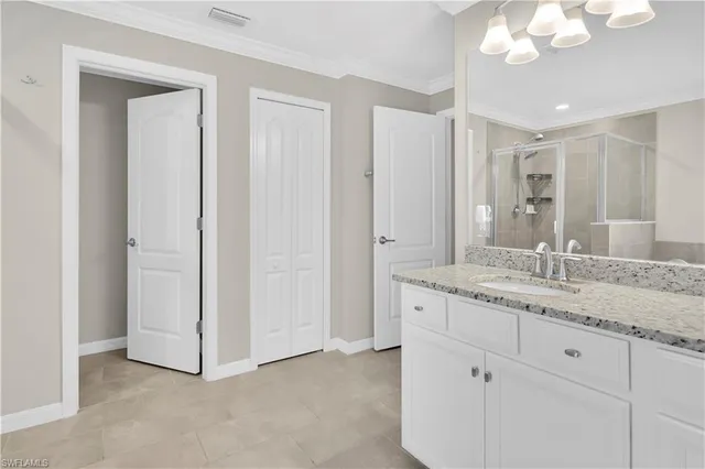 a bathroom with a granite countertop sink mirror and cabinets
