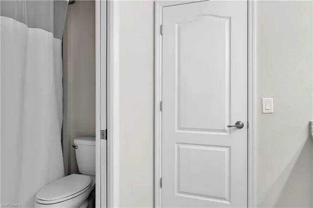 a white toilet sitting next to a shower