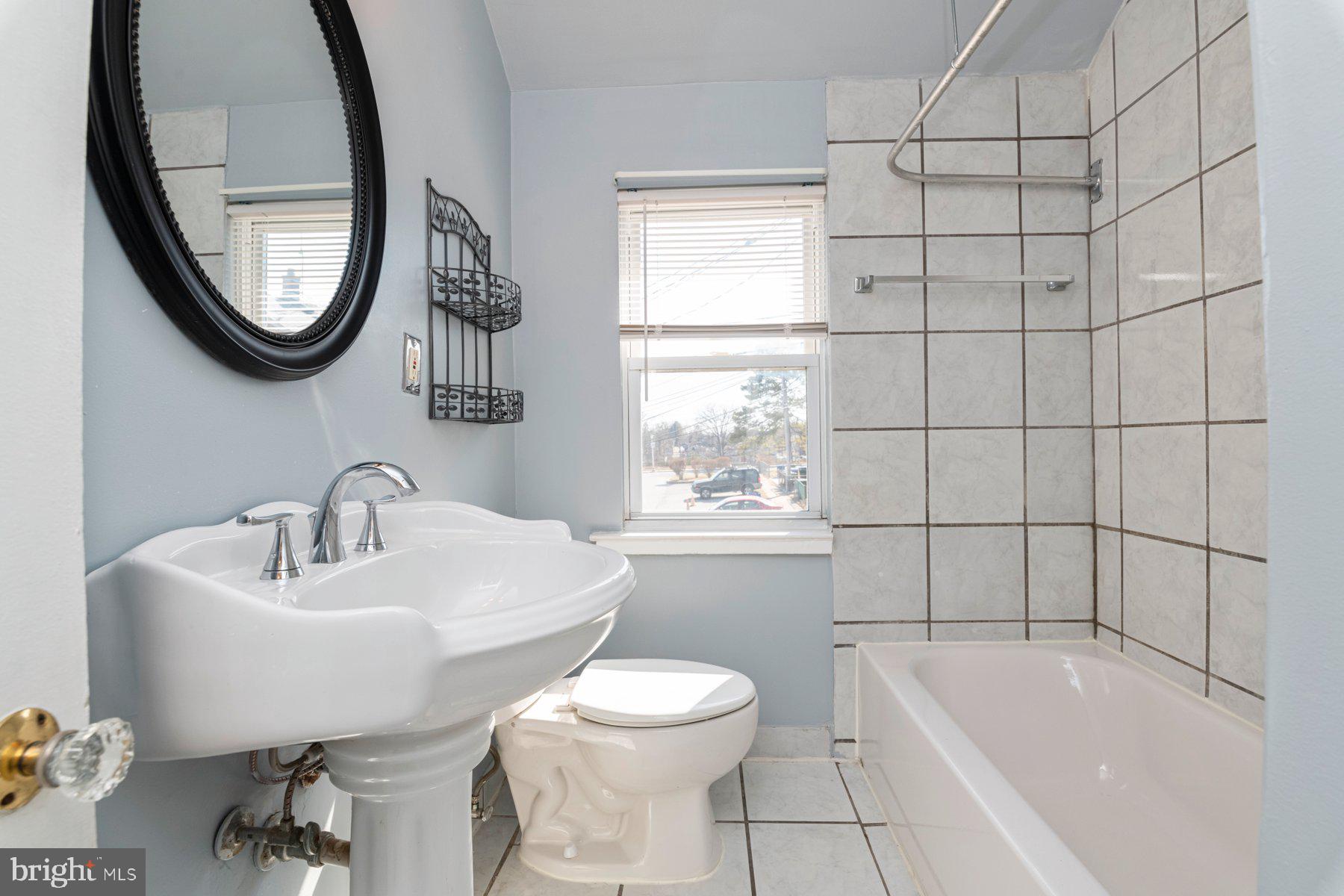 1039 Cameron Road Baltimore, MD 21212 - Photo 17 of 26 a bathroom with a sink toilet a mirror and tub