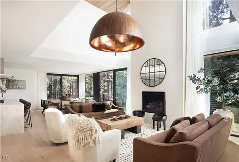 a living room with furniture a fireplace and a large mirror