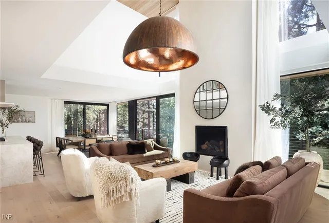 a living room with furniture a fireplace and a large mirror