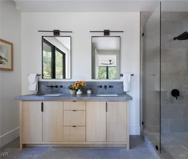 a bathroom with double vanity and a mirror