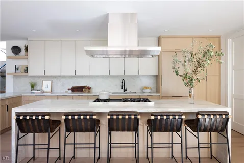 a kitchen with granite countertop a table chairs stove and cabinets