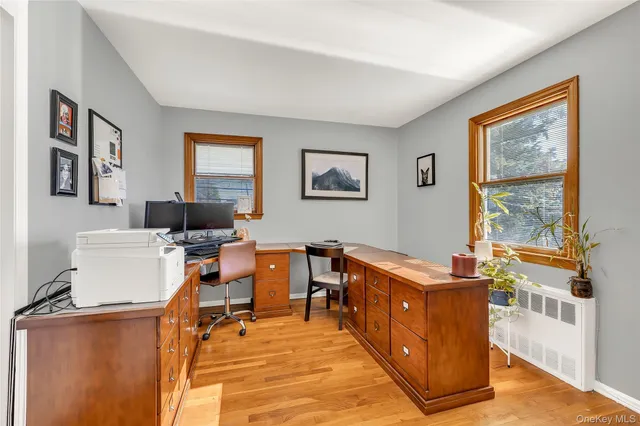 a view of a workspace with furniture and a window