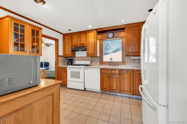 a kitchen with a sink appliances cabinets and furniture