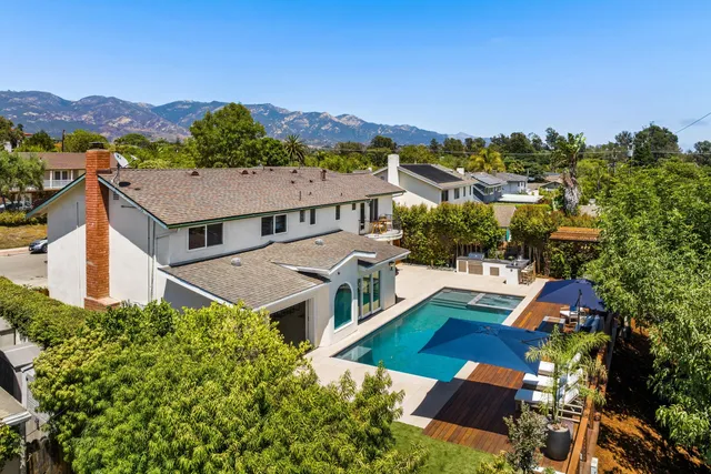 an aerial view of multiple houses with a city view