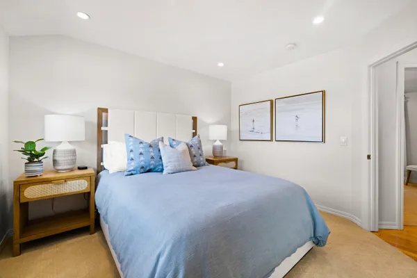 a spacious bedroom with a bed and a chandelier