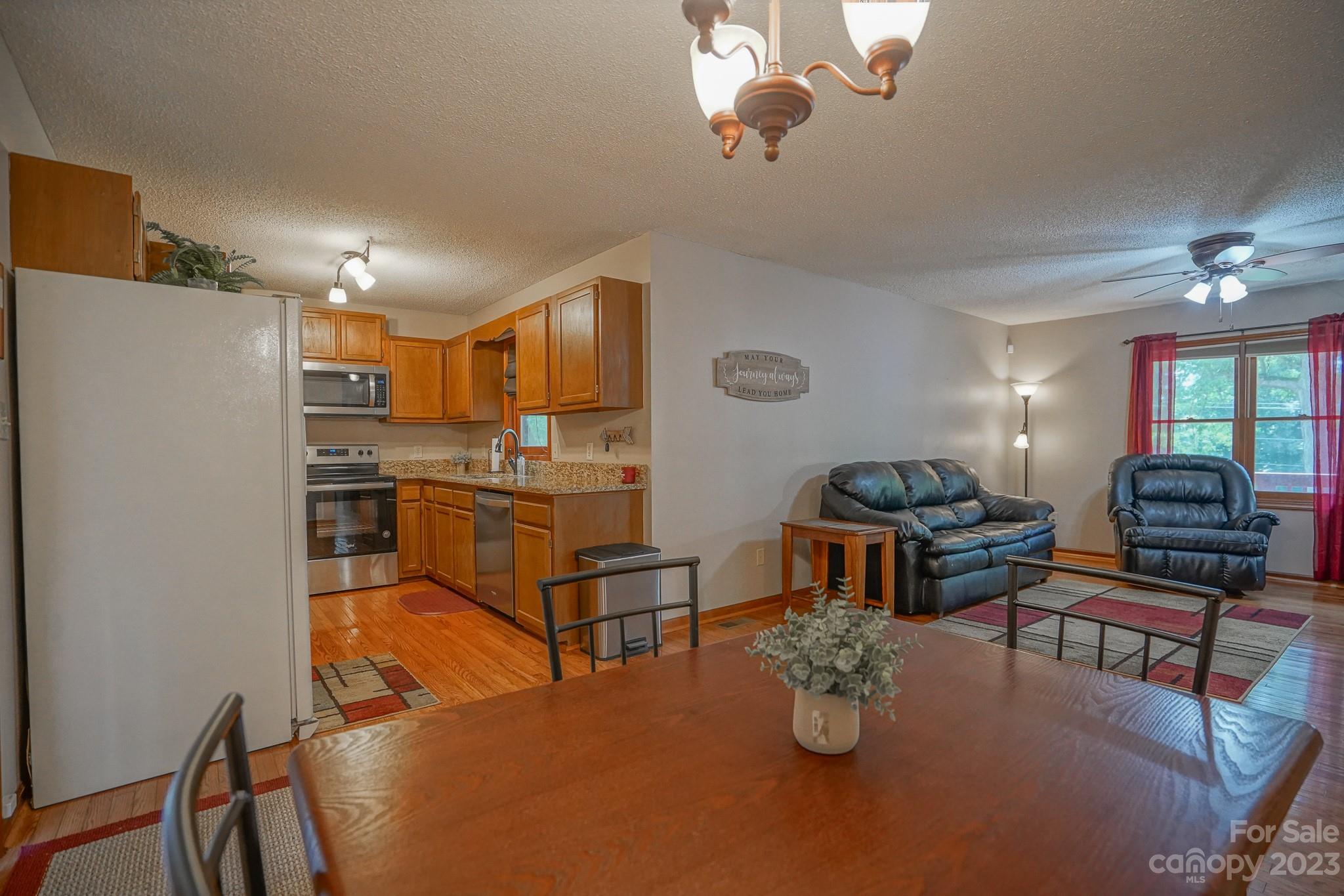 2743 Harmony Highway Harmony, NC 28634 - Photo 29 of 47 a kitchen with stainless steel appliances granite countertop a stove refrigerator a dining table and chairs with wooden floor