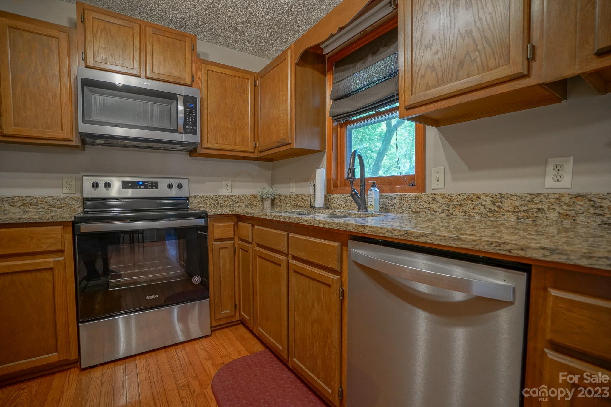 2743 Harmony Highway Harmony, NC 28634 - Photo 34 of 47 a kitchen with granite countertop wood cabinets stainless steel appliances and a sink