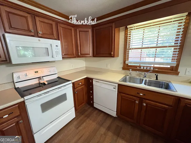 a kitchen with granite countertop wooden cabinets sink and window