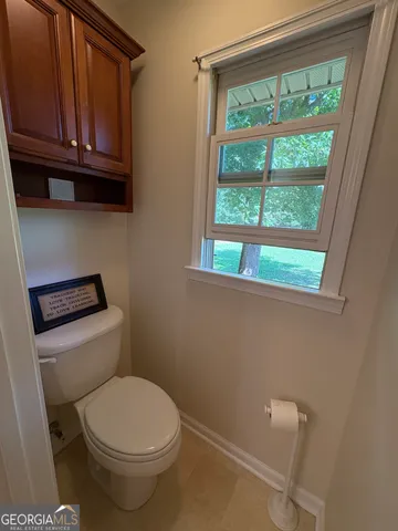 a bathroom with a toilet a sink and a window