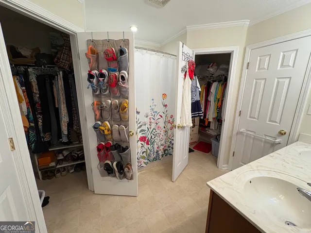 a view of walk in closet with clothes and shoes