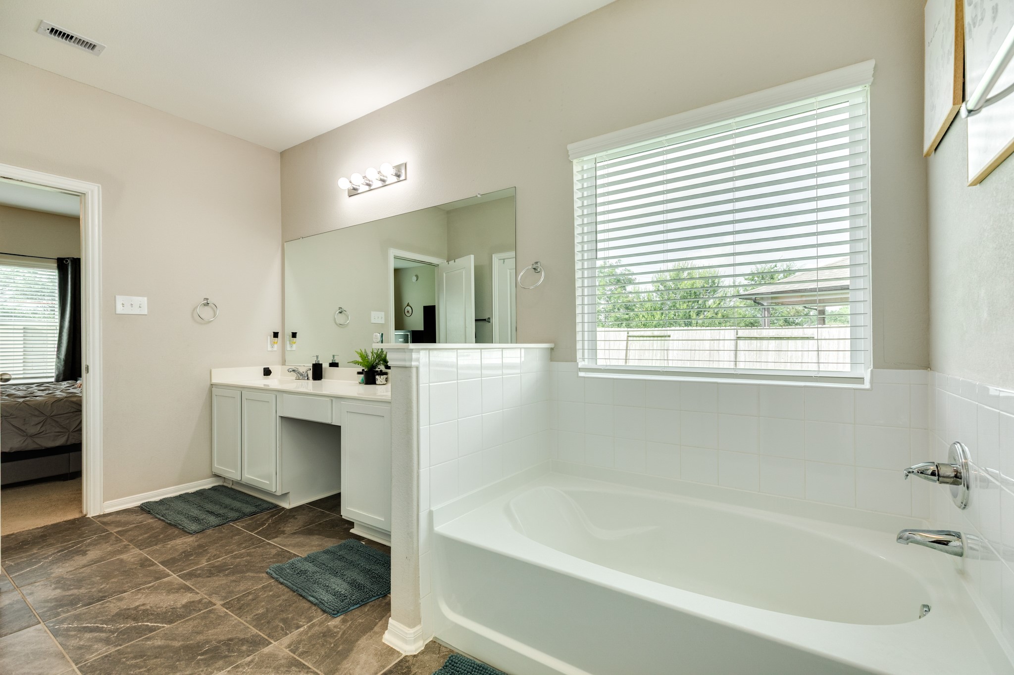 2446 Palisade Crst Drive Rosharon, TX 77583 - Photo 20 of 30 This bathroom features a spacious layout with a large bathtub, a double vanity with ample counter space, and a big window providing natural light. The neutral color scheme adds a modern touch.