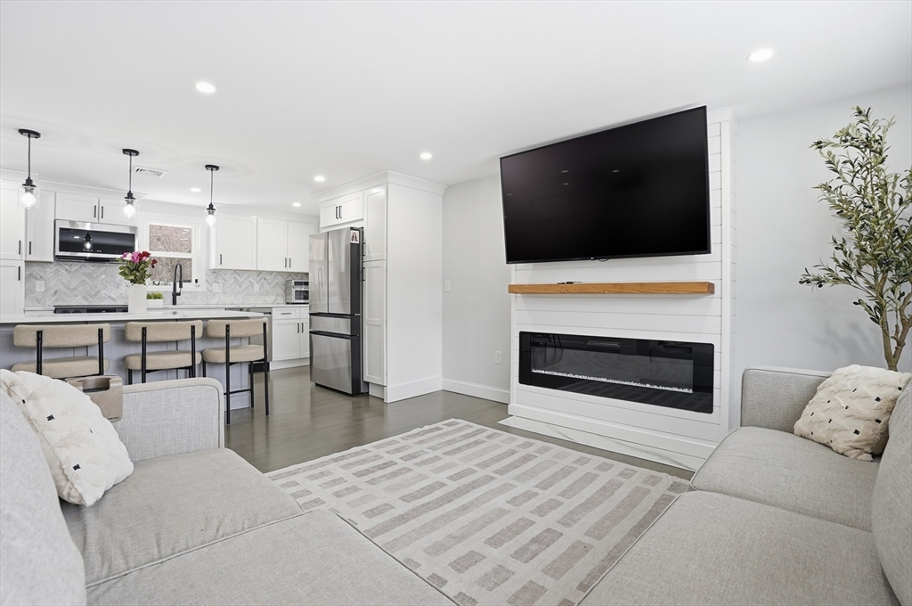 82 Water Street Saugus, MA 01906 - Photo 6 of 40 a living room with furniture a flat screen tv and kitchen view