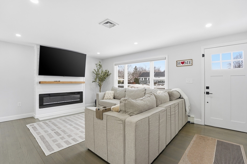 82 Water Street Saugus, MA 01906 - Photo 7 of 40 a living room with furniture a flat screen tv and a fireplace