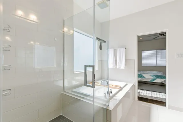 a bathroom with a granite countertop sink a mirror and shower