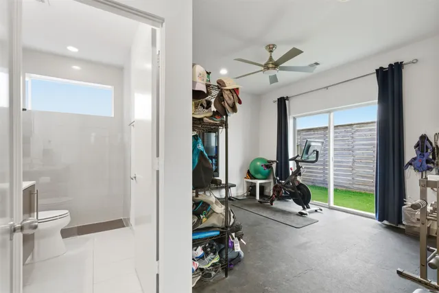 a living room with furniture gym equipment and a large window