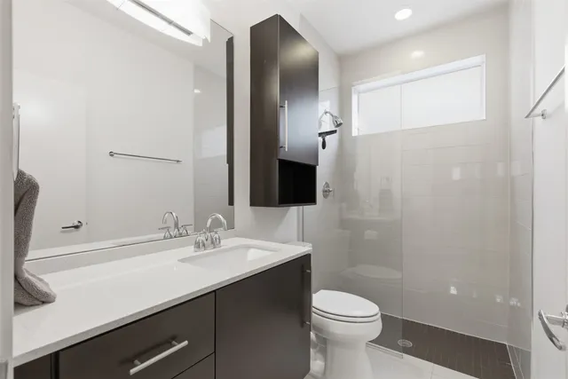 a bathroom with a sink a toilet and shower