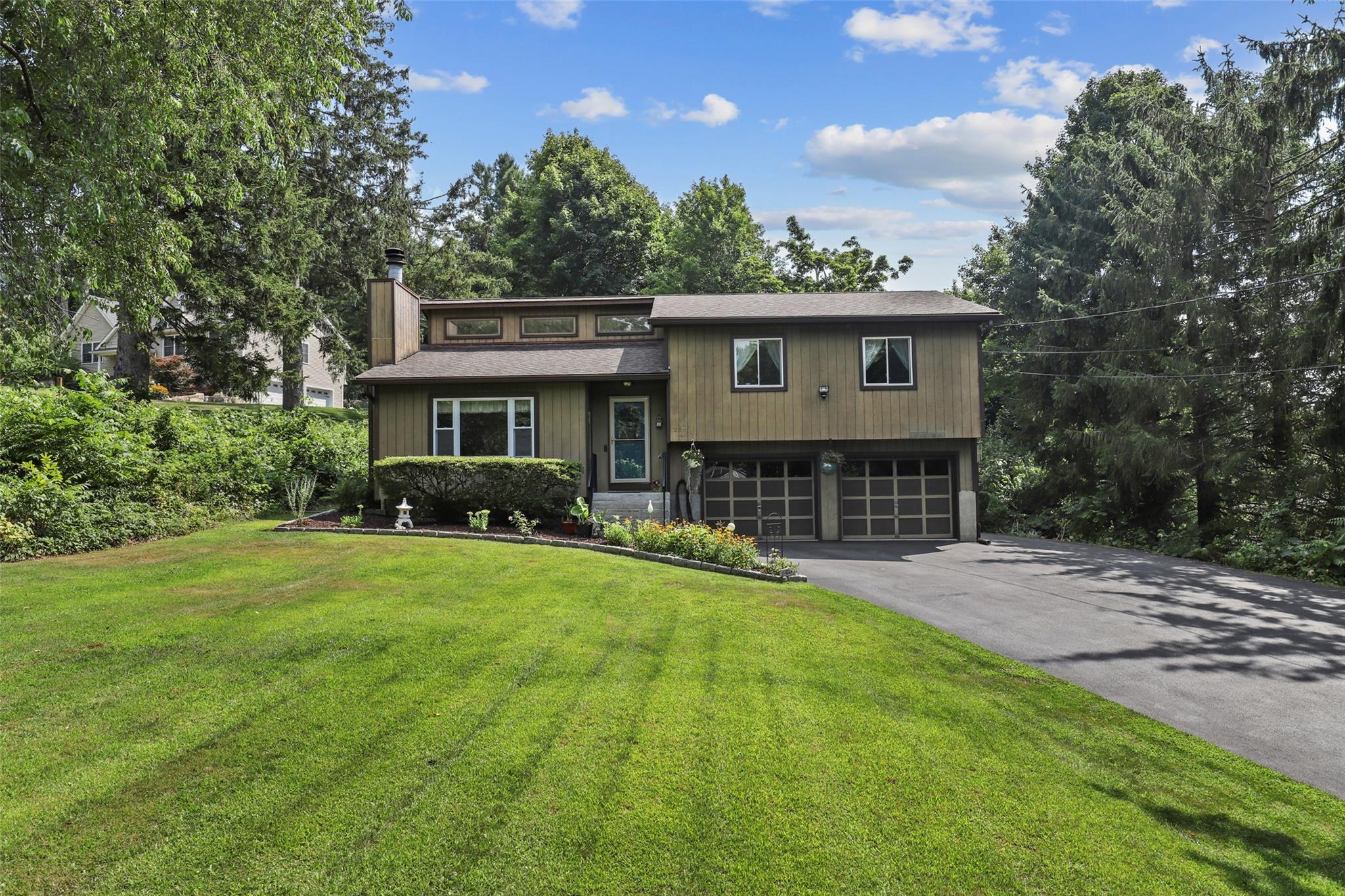 287 Union Valley Road Mahopac, NY 10541 - Photo 1 of 1 View of front of home featuring asphalt driveway, a garage, a front lawn, a chimney, and roof with shingles