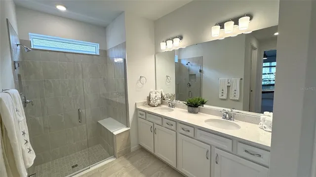 a bathroom with a double vanity sink mirror double and shower
