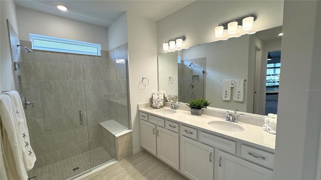 9408 Coastline Way Palmetto, FL 34221 - Photo 11 of 41 a bathroom with a double vanity sink mirror double and shower
