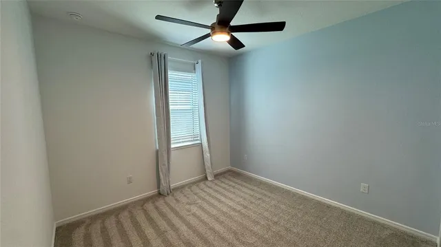 an empty room with closet and fan