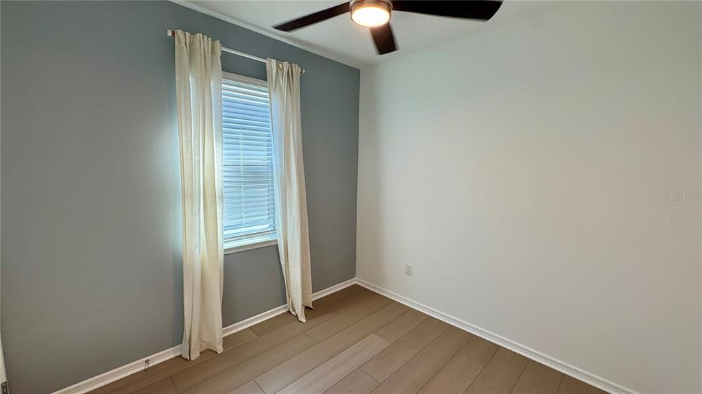 9408 Coastline Way Palmetto, FL 34221 - Photo 19 of 41 an empty room with wooden floor cabinet and hallway