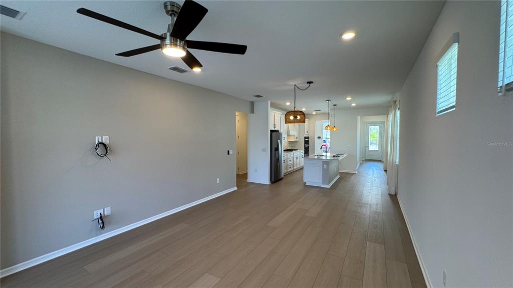 9408 Coastline Way Palmetto, FL 34221 - Photo 4 of 41 an empty room with wooden floor and a ceiling fan