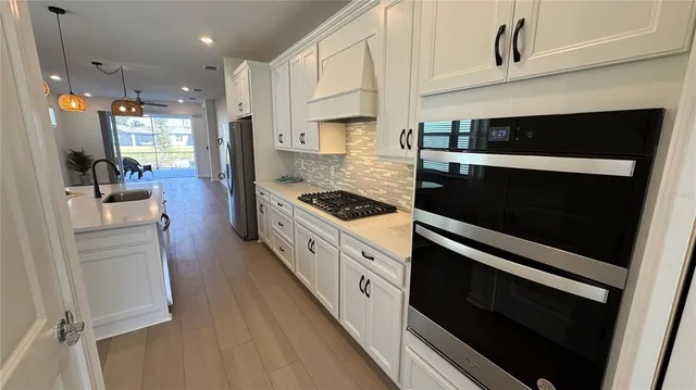 a kitchen with stainless steel appliances kitchen island granite countertop a stove a sink and a refrigerator