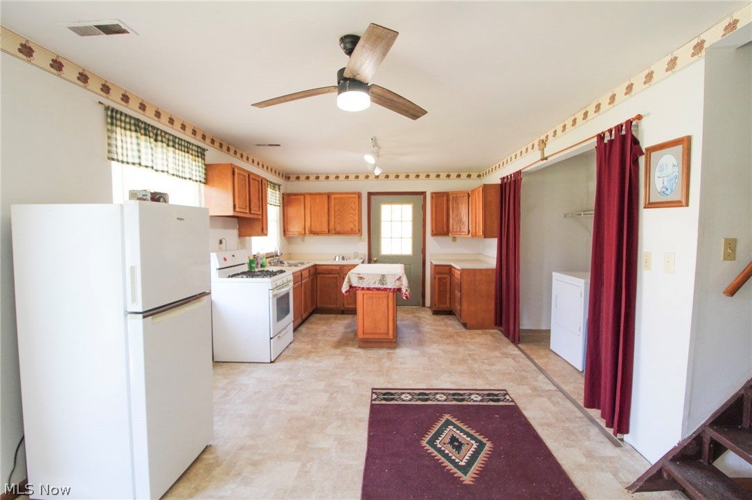 39353 Walnut Camp Road Sardis, OH 43946 - Photo 9 of 42 Kitchen featuring white appliances, light tile flooring, ceiling fan, sink, and a center island