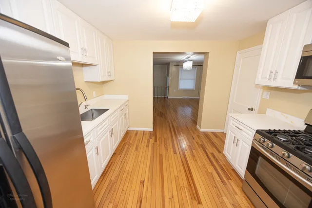 a kitchen with a sink and wooden floor