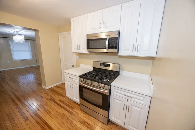 a kitchen with granite countertop cabinets stainless steel appliances and wooden floor