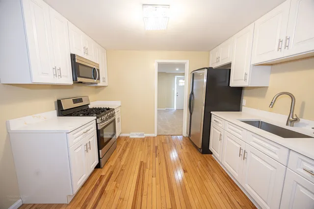 a kitchen with a sink a refrigerator and cabinets