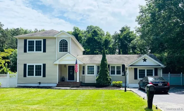 a front view of a house with a yard porch and a tree