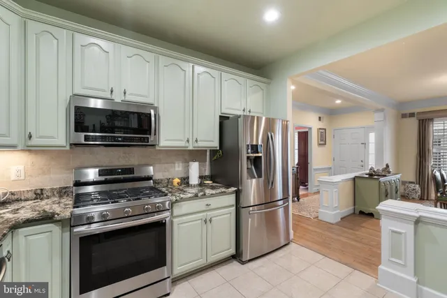 a kitchen with stainless steel appliances granite countertop a refrigerator stove and microwave