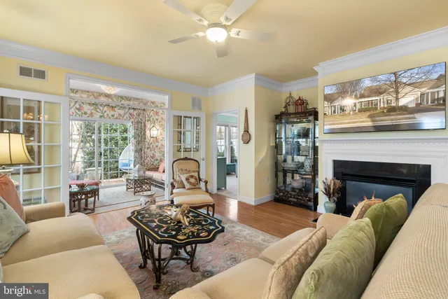 a living room with furniture a fireplace and a large window with garden view
