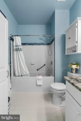 a bathroom with a granite countertop sink a toilet and a bathtub