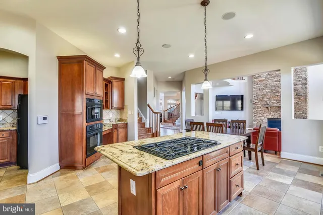 a spacious bedroom with a bed a dresser and wooden floor