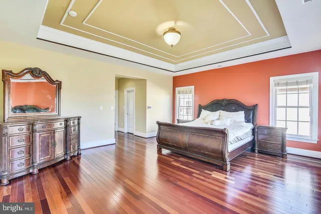a view of a hallway with wooden floor and windows