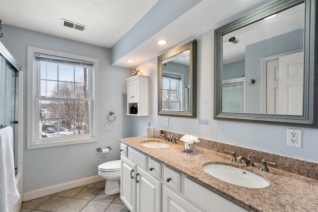 21 Hartwell Place, Unit 21 Canton, MA 02021 - Photo 24 of 33 a bathroom with a granite countertop toilet a sink and a mirror