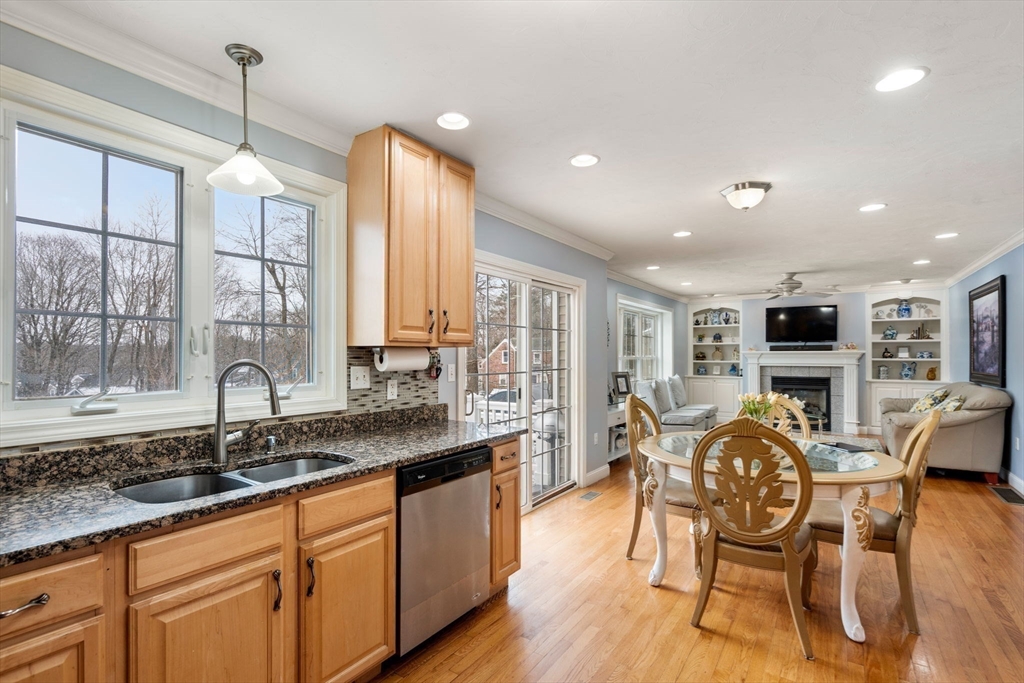 21 Hartwell Place, Unit 21 Canton, MA 02021 - Photo 7 of 33 a open kitchen with stainless steel appliances granite countertop a stove top oven a sink a dining table and chairs with wooden floor