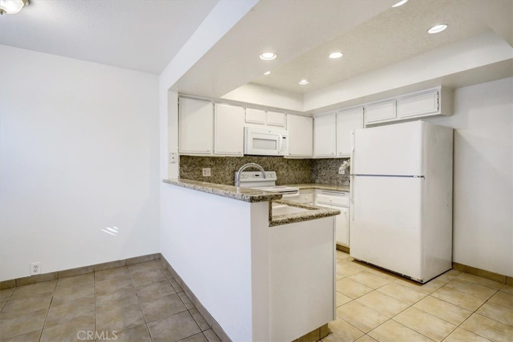 1333 Valley View Road, Unit 18 Glendale, CA 91202 - Photo 12 of 52 a kitchen with a refrigerator a stove top oven and cabinets