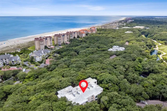 a view of a balcony with a couple of cars parked in front of house