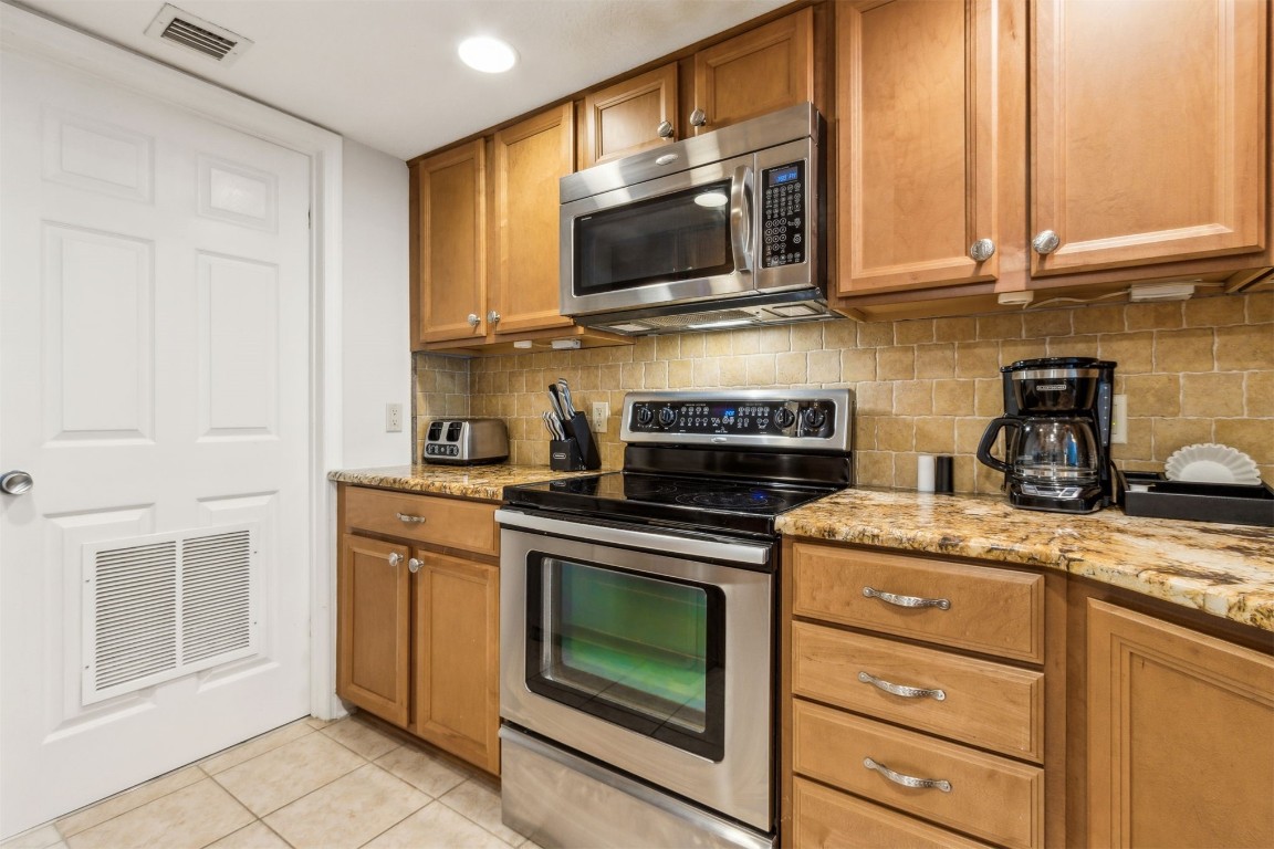 2123 Beachwood Road, Unit 2123 Fernandina Beach, FL 32034 - Photo 10 of 64 a kitchen with granite countertop a stove top oven microwave and cabinets